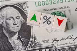 Image of U.S. currency with tiles showing a green up arrow for a rise in interest rates and a red arrow for a fall.