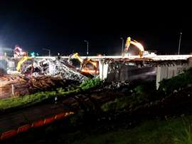 Excavators carry out night works, dismantling the bridge